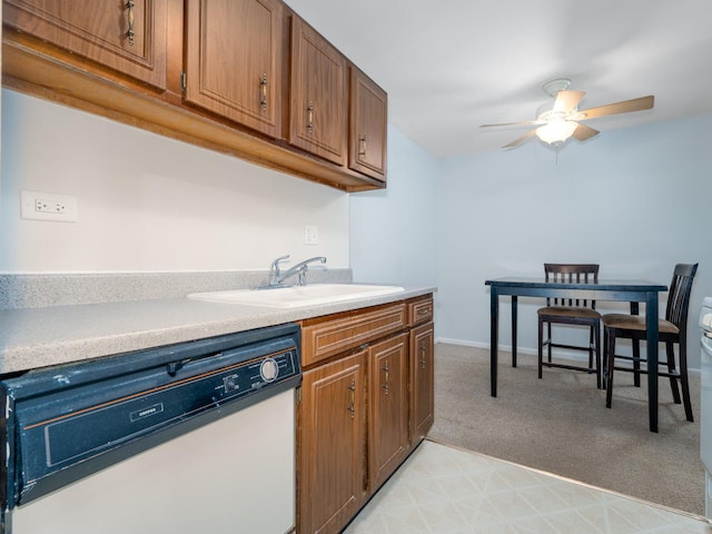 kitchen with a ceiling fan, white dishwasher, light carpet, and light countertops