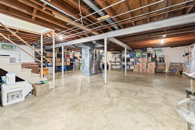 unfinished basement featuring water heater, stairs, and heating unit