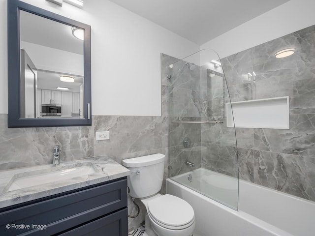 bathroom featuring toilet, bathtub / shower combination, tile walls, backsplash, and vanity