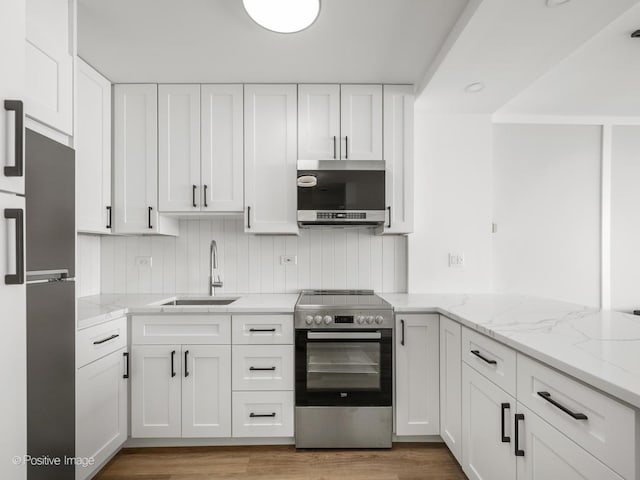 kitchen featuring white cabinetry, light stone counters, stainless steel appliances, and a sink
