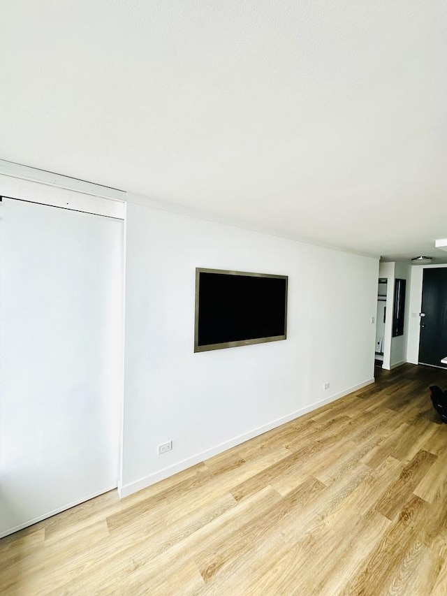 unfurnished living room with baseboards and wood finished floors
