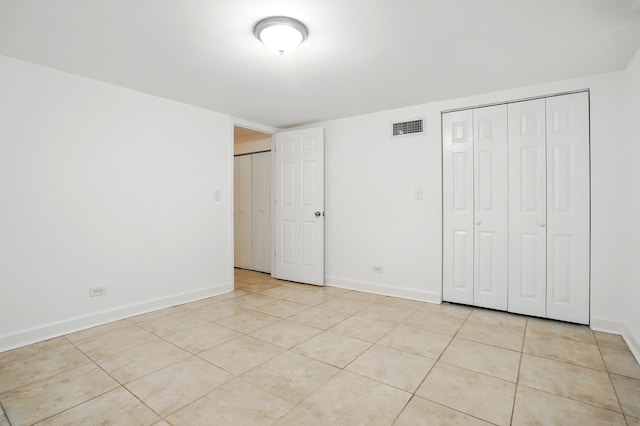 unfurnished bedroom with light tile patterned flooring and baseboards