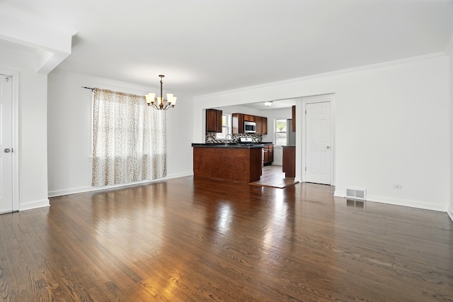 unfurnished living room featuring a chandelier, dark wood-style floors, a sink, and baseboards
