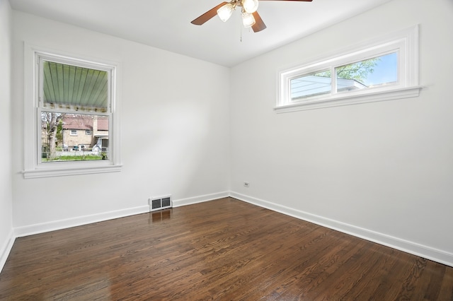 unfurnished room featuring baseboards, dark wood-type flooring, and ceiling fan