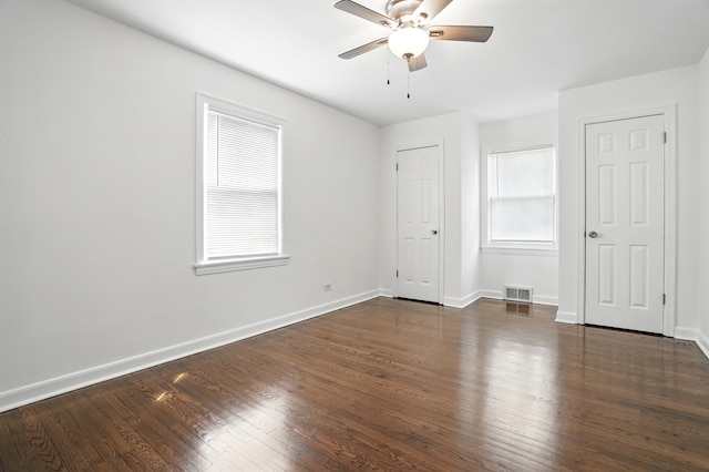 unfurnished bedroom with dark wood-style floors, baseboards, and a ceiling fan