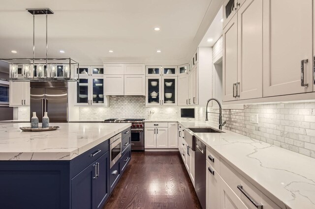 1955 N Halsted St Unit 1, Chicago, IL 60614 - kitchen with built in appliances, white cabinetry, a sink, dark wood finished floors, and light stone counters