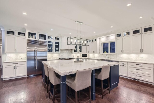 1955 N Halsted St Unit 1, Chicago, IL 60614 - kitchen with premium appliances, a sink, ornamental molding, white cabinets, and a center island