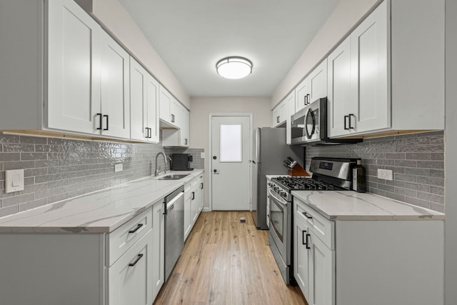 559 Coolidge Ave, Glen Ellyn, IL 60137 - kitchen featuring stainless steel appliances, a sink, tasteful backsplash, light wood finished floors, and light stone countertops