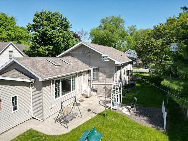 214 W Watson St, Forrest, IL 61741 - rear view of property with roof with shingles, a patio, a lawn, and stone siding