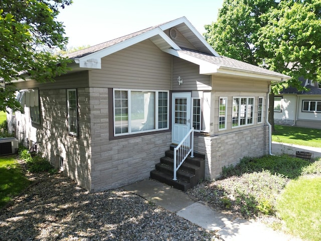 214 W Watson St, Forrest, IL 61741 - view of front of house featuring entry steps, stone siding, and central AC