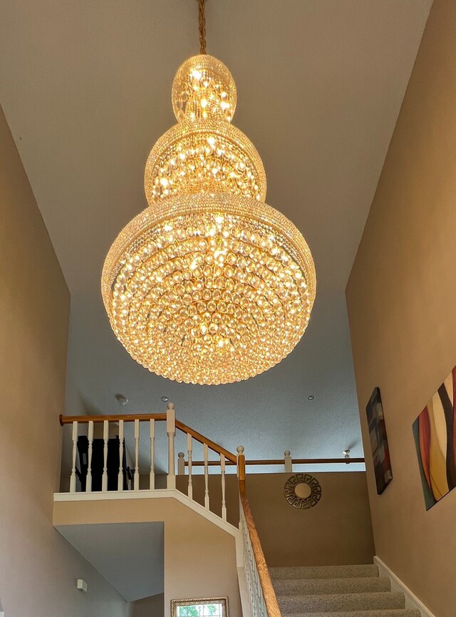 staircase with a chandelier and carpet flooring