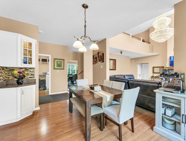 dining area with a tray ceiling, baseboards, and light colored carpet
