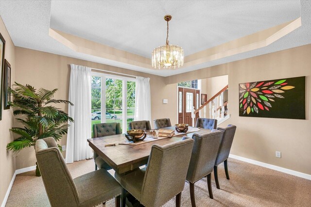 living room with a high ceiling, a chandelier, wood finished floors, a tile fireplace, and baseboards