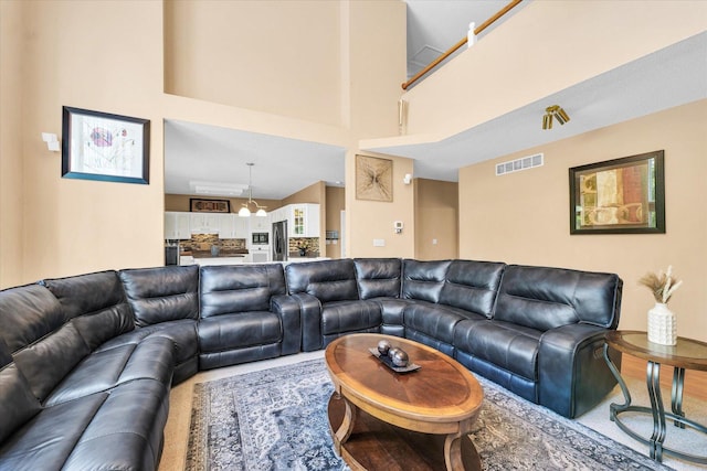 living room featuring a towering ceiling and carpet