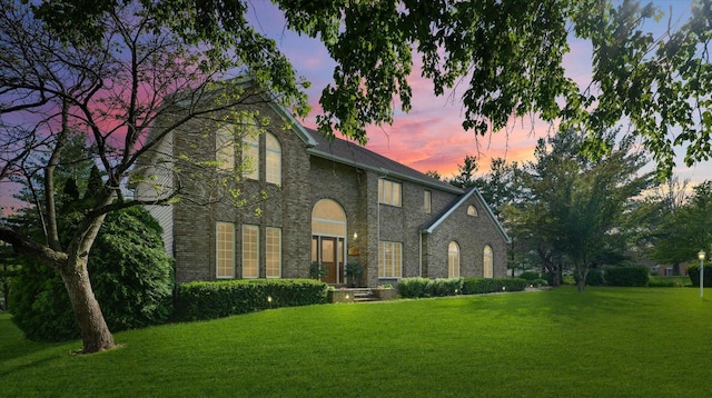 view of front facade featuring a yard and brick siding