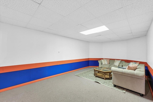 carpeted living area featuring a drop ceiling
