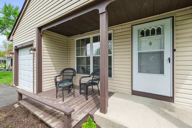 wooden deck with covered porch and an attached garage