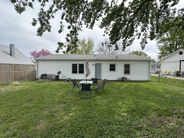 back of property featuring a lawn and a fenced backyard