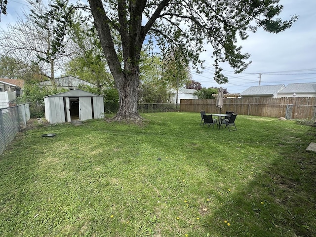 view of yard featuring a fenced backyard, a storage shed, and an outdoor structure