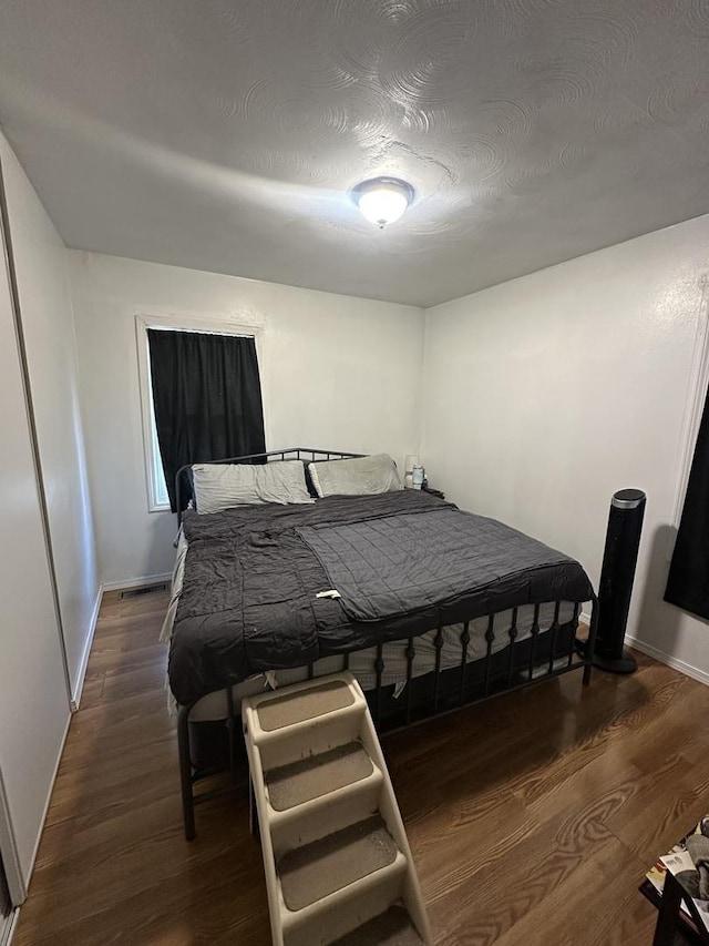 bedroom featuring baseboards and wood finished floors