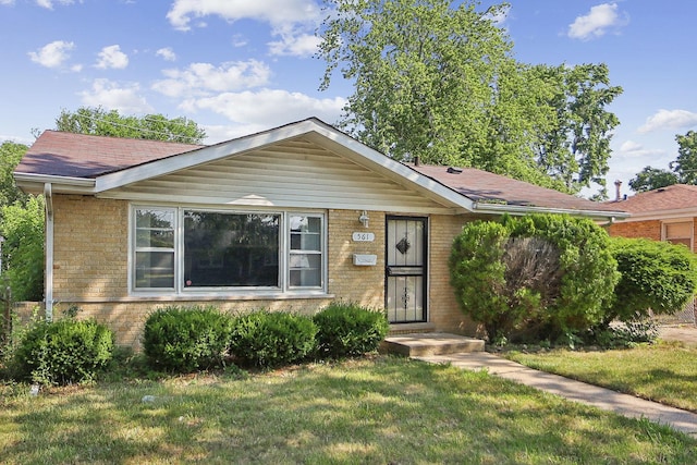 561 Minette Ln, Chicago Heights, IL 60411 - view of front of house with brick siding, a front lawn, and roof with shingles