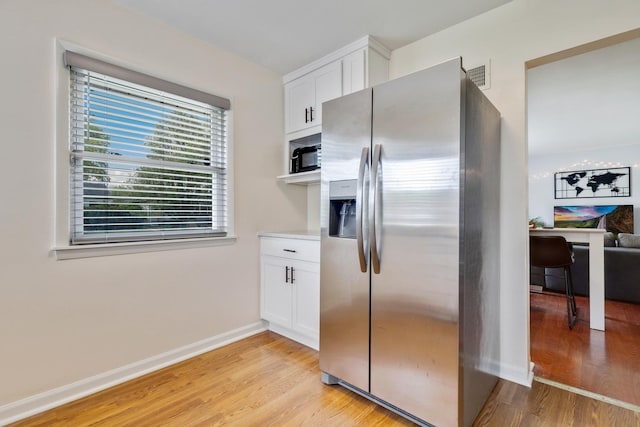 3668 Adams St, Lansing, IL 60438 - kitchen featuring stainless steel fridge, light wood-style floors, white cabinetry, and baseboards