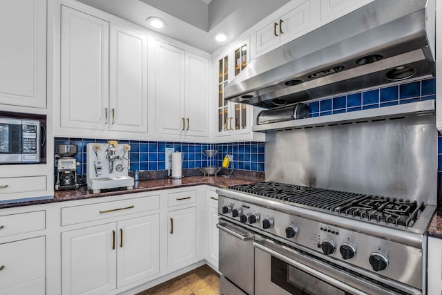 kitchen with under cabinet range hood, appliances with stainless steel finishes, and white cabinetry