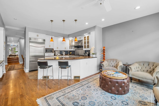 living room featuring ceiling fan, recessed lighting, visible vents, and light wood-style floors