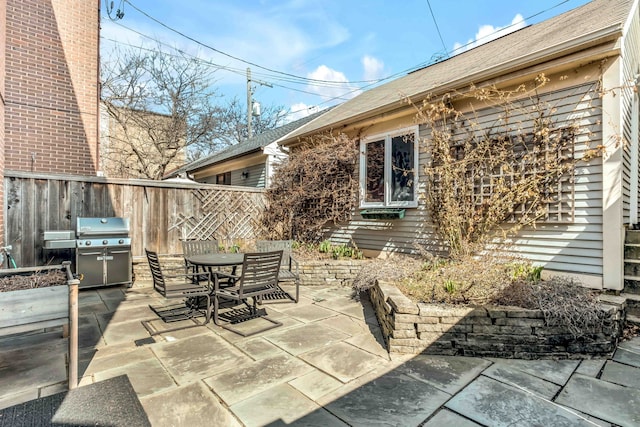 view of patio with area for grilling, fence, and outdoor dining space