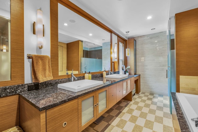 bathroom featuring recessed lighting, double vanity, a sink, and a tub