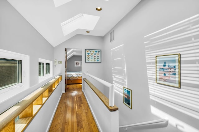 hall with recessed lighting, visible vents, vaulted ceiling with skylight, and wood finished floors