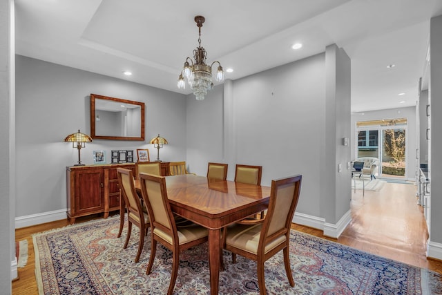 dining area with a chandelier, baseboards, light wood-type flooring, and recessed lighting
