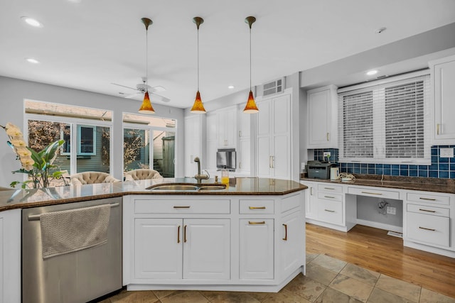 kitchen featuring a sink, stainless steel dishwasher, white cabinetry, and pendant lighting