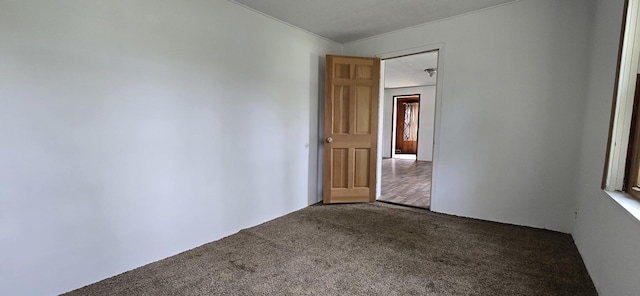 spare room with dark colored carpet