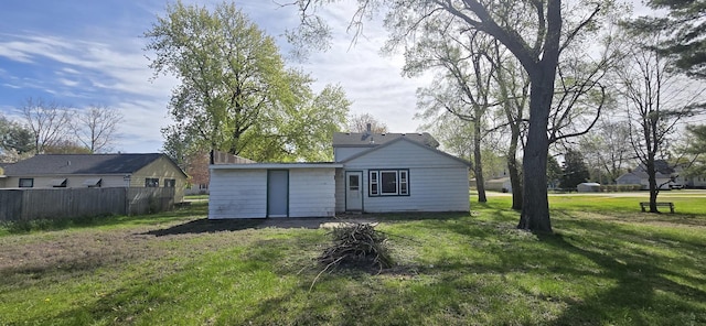 rear view of house with a yard and fence