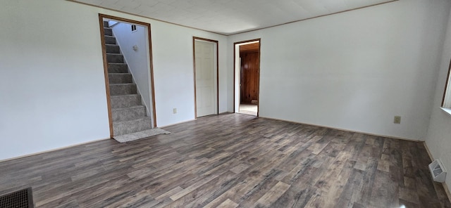 interior space with dark wood finished floors, visible vents, and stairs