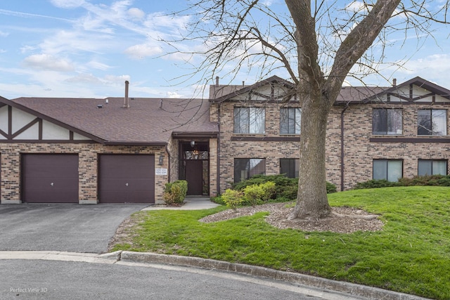 view of front of house featuring driveway, brick siding, an attached garage, a shingled roof, and a front yard