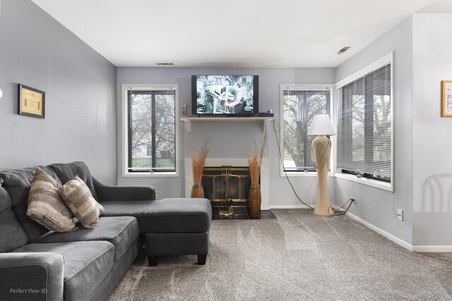 living room with a fireplace with flush hearth, carpet floors, baseboards, and visible vents