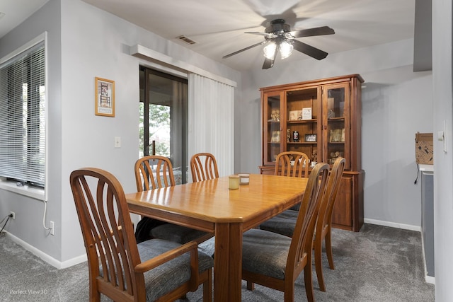 dining area featuring a ceiling fan, dark carpet, baseboards, and visible vents