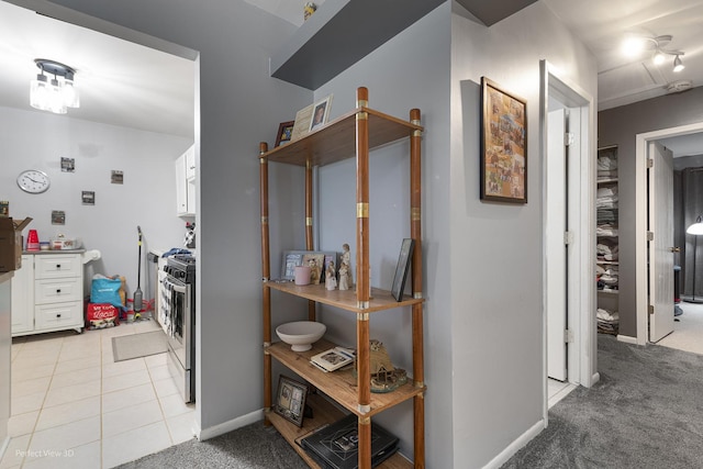 hallway with light carpet and light tile patterned flooring