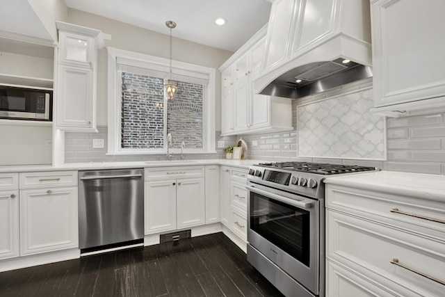 435 W Roslyn Pl Unit 2E, Chicago, IL 60614 - kitchen featuring stainless steel appliances, light countertops, custom exhaust hood, white cabinets, and dark wood finished floors