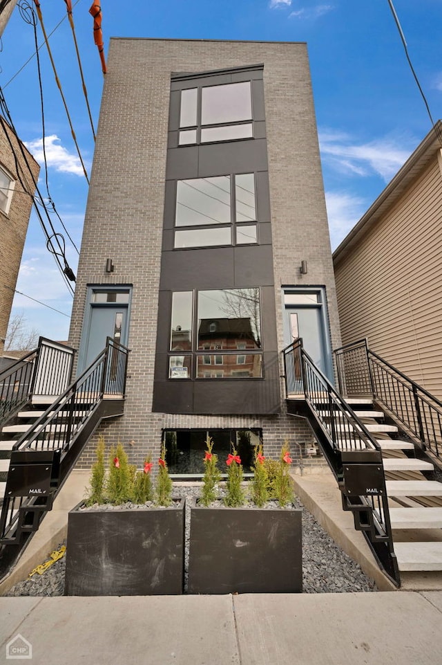 exterior space with stairway and brick siding