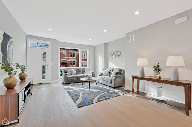 living area featuring light wood-type flooring, recessed lighting, baseboards, and visible vents