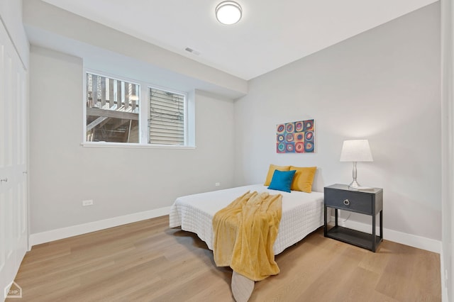 bedroom featuring visible vents, wood finished floors, and baseboards