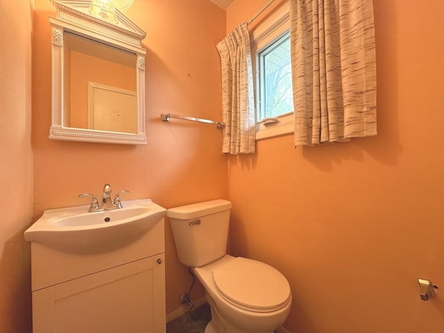 half bath featuring vanity and toilet