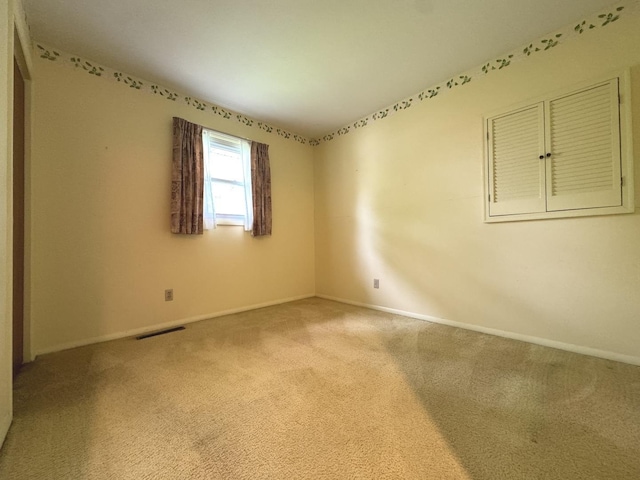 carpeted empty room with baseboards and visible vents