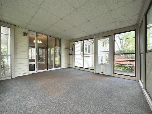interior space with a paneled ceiling, a wealth of natural light, and carpet flooring