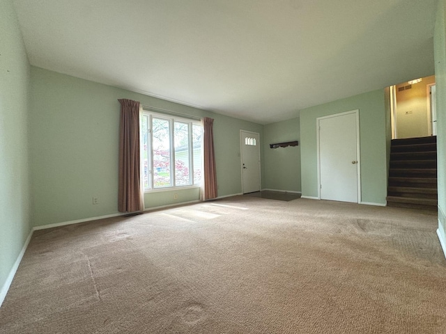 unfurnished living room with carpet and baseboards