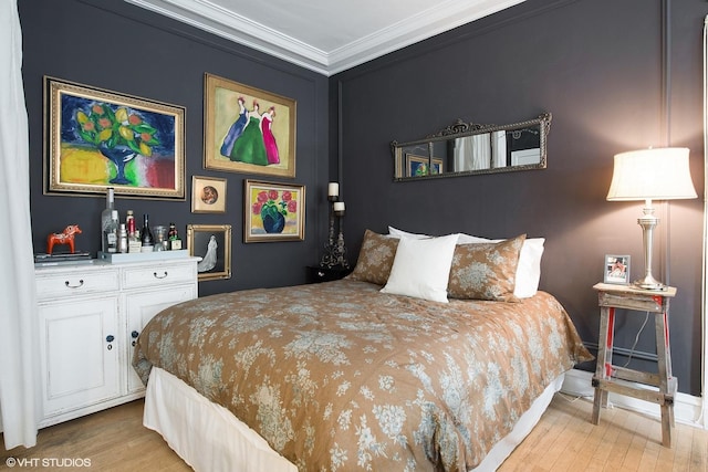 bedroom with crown molding and wood finished floors