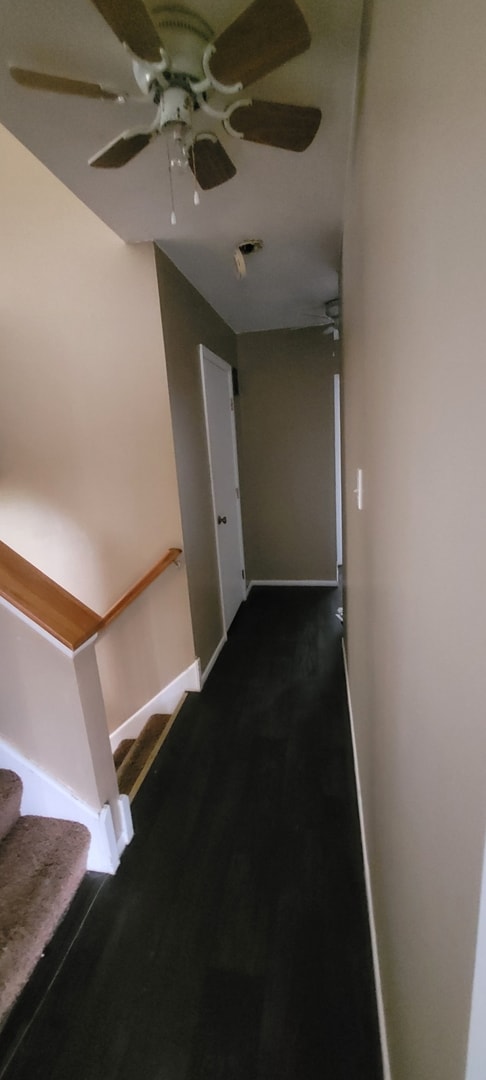 hallway with baseboards and dark wood finished floors
